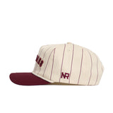 The No Rivals Florida State Walk Off Hat is a cream cotton baseball cap with thin burgundy stripes, a burgundy brim, and "NR" embroidered in burgundy above the left brim. It has an unstructured fit for relaxed comfort.