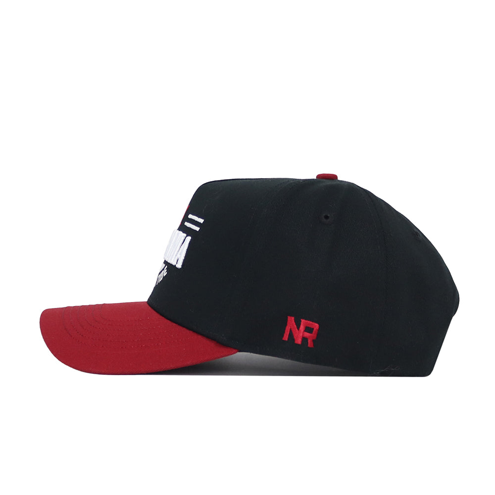 The Alabama Tailgate Hat by No Rivals is a black structured snapback with a red bill, featuring red NR embroidery on the side and partially visible white embroidery on the front, all crafted from high-quality cotton.