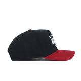 The Alabama Tailgate Hat by No Rivals is a black snapback with a curved dark red brim, seen from the side. Made from high-quality cotton, it showcases white embroidered text and design on the structured front.