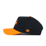 The Tennessee Tailgate Hat by No Rivals features a black cotton build with an orange brim and embroidered NR initials on the side in a structured fit, shown from the side on a white background.