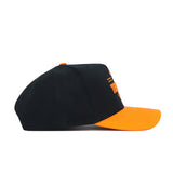 The Tennessee Tailgate Hat by No Rivals is a black snapback with an orange brim, structured fit, orange stitching, top button, and partial orange text and design on the front panel. Made from high quality cotton and shown from the side.
