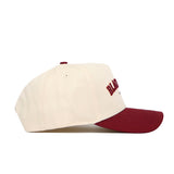 The No Rivals Blacksburg Hometown Hat is a cream snapback with a maroon brim and front embroidery, made from premium cotton, displayed side-on against a white background.