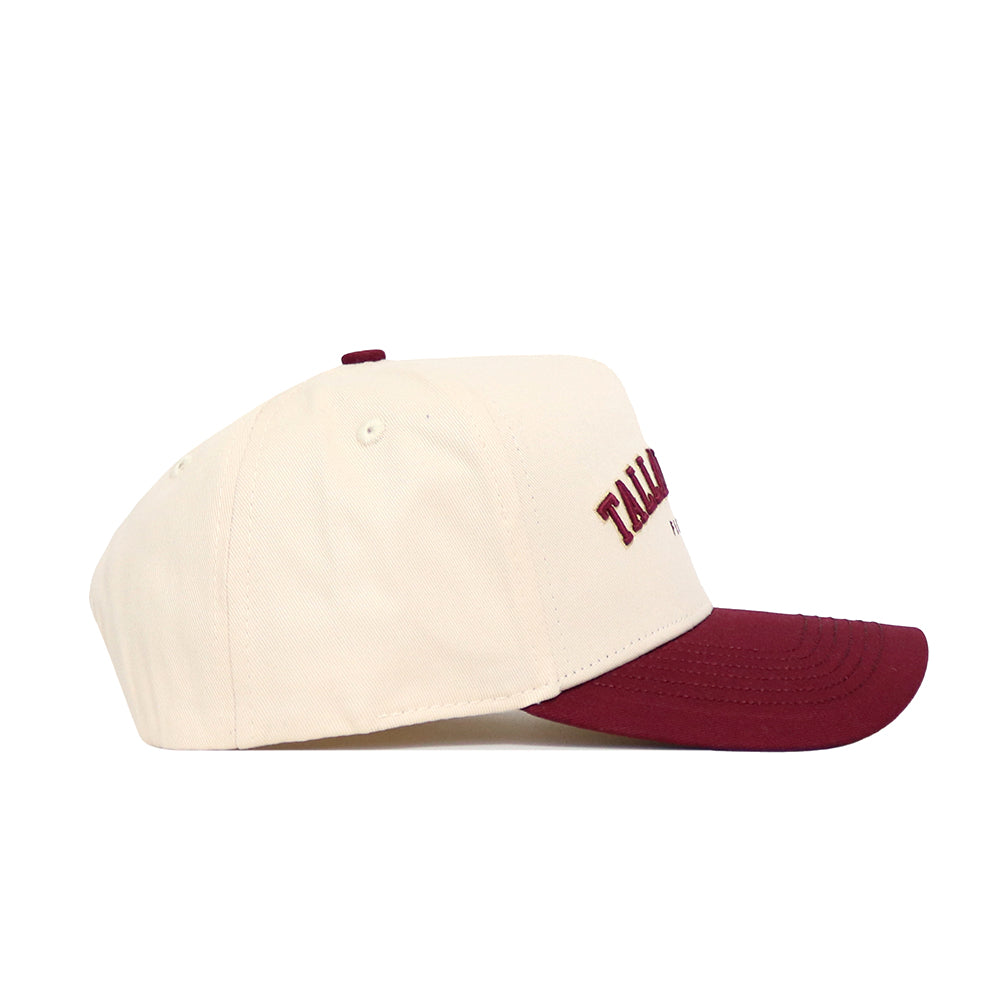 The No Rivals Tallahassee Hometown Hat is a cream-colored snapback with a structured fit, maroon brim, and matching maroon embroidered front text, shown from the side on a white background.