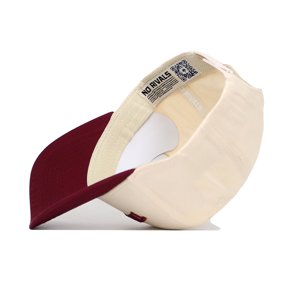 The Tallahassee Hometown Hat by No Rivals is a cream cotton baseball cap with a maroon brim, shown upside down to display its NO RIVALS label, interior QR code, branded text, and structured fit.