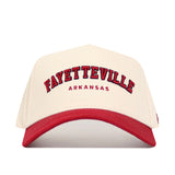 The No Rivals Fayetteville Hometown Hat is a cream, structured-fit cap with a red brim. Made of quality cotton, it features bold red "Fayetteville" text outlined in black, "Arkansas" beneath, and an adjustable snapback for a perfect fit.