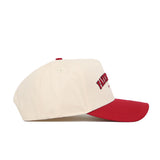 The No Rivals Fayetteville Hometown Hat is a cream baseball cap with a red brim and button, made from high-quality cotton. It features embroidered red text, a structured fit, snap back closure, and is shown side view on a white background.