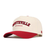 The No Rivals Fayetteville Hometown Hat is a cream cotton cap with a red brim, featuring "FAYETTEVILLE" in red and black above "ARKANSAS" in smaller red print. This structured fit offers comfort and classic style.