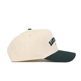 The No Rivals East Lansing Hometown Hat is a cream cotton snapback baseball cap featuring a dark green curved brim and embroidered front text, shown from a side view against a white background.