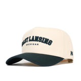 The East Lansing Hometown Hat by No Rivals is a cream snapback with "EAST LANSING MICHIGAN" in dark green on the front, a structured fit, dark green curved brim, cotton fabric, and a small N logo on the side.