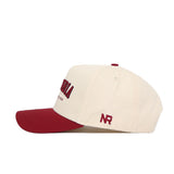 The No Rivals Columbia Hometown Hat is a cream snapback with a maroon brim, crafted from high-quality cotton. It features maroon NR initials embroidered on the side and maroon with black embroidery on the front for a structured fit.