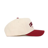 The Columbia Hometown Hat by No Rivals is a beige cotton baseball cap with a structured fit, maroon brim and button, and maroon embroidered front text, displayed in side profile against a white background.
