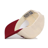 The Columbia Hometown Hat by No Rivals is shown upside down, revealing its beige and maroon design, inner tags, "NO RIVALS" label, QR code on the sweatband, and a structured fit with detailed craftsmanship.