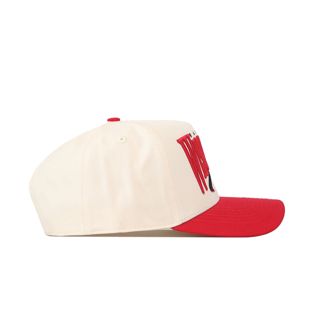 A side view of the Wisconsin Badgers Stride Hat by No Rivals, featuring a cream-colored snap back design with a red brim. This structured fit cap is made from high-quality cotton, and bold red lettering can be seen partially on the front.