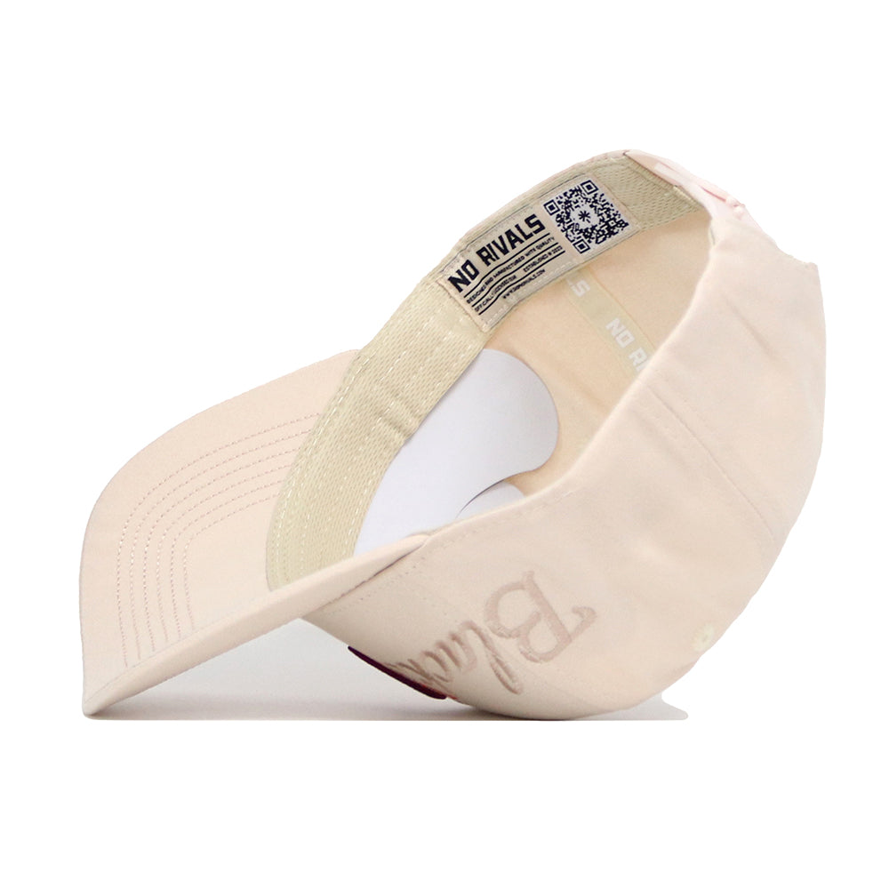 The Virginia Tech Stacked Hat by No Rivals is shown upside down, revealing the interior band with a QR code and "NO RIVALS" printed inside. The beige cotton cap features detailed brim stitching and a bold "B" embroidered on the outside.