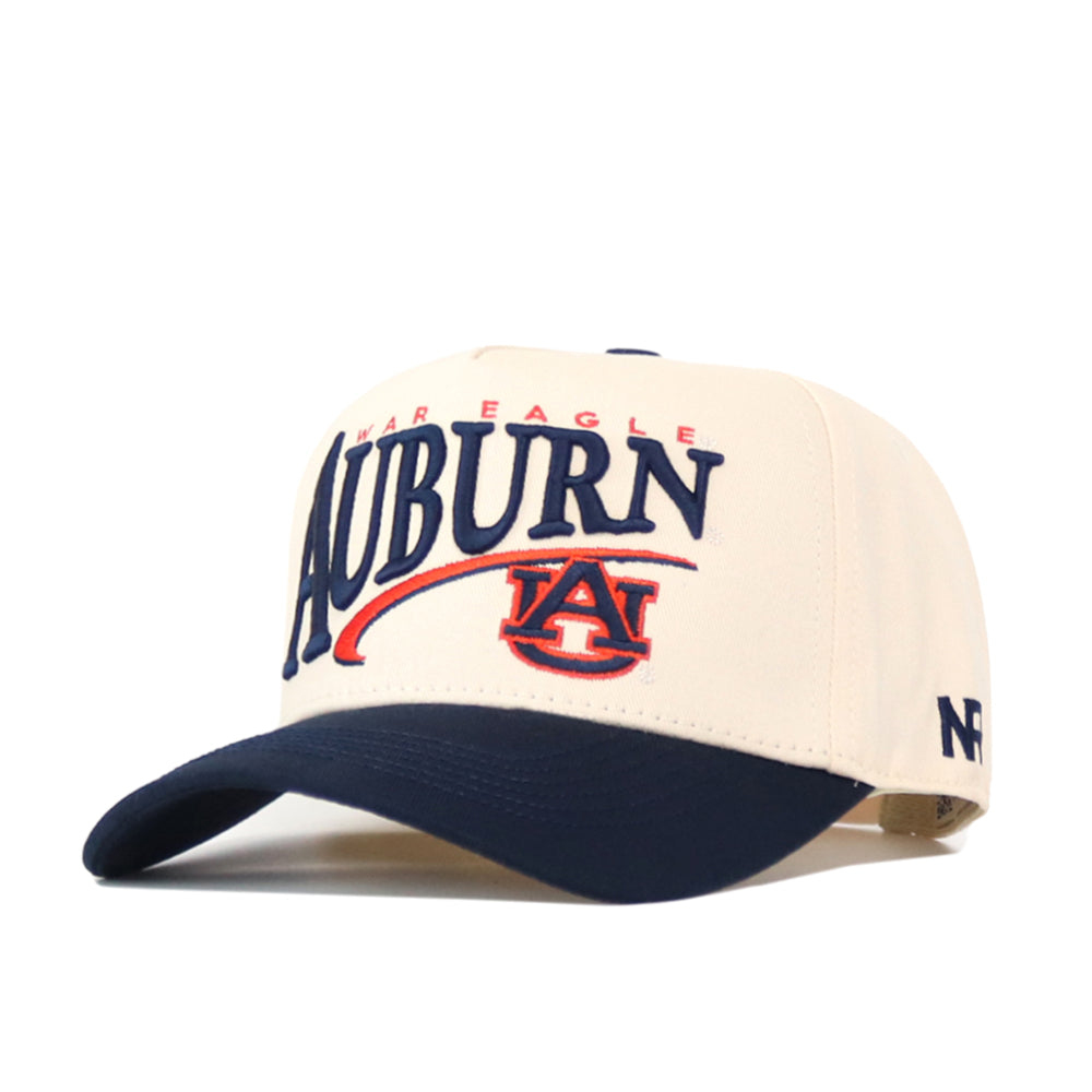 The No Rivals Auburn Tigers Stride Hat is a cream and navy snapback baseball cap, officially licensed and featuring embroidered Auburn and AU logos on the front, “War Eagle” above, and “NF” on the side for authentic team spirit.