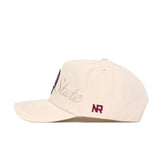 The No Rivals Florida State Stacked Hat is a beige snapback cap made of high quality cotton, featuring "State" embroidered in cursive on the side and "NR" stitched in maroon near the back. It has a curved brim, structured fit, and visible top stitching.