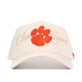 The No Rivals Clemson Stacked Hat is a beige structured snapback featuring an orange tiger paw print and "Clemson Tigers" in cursive embroidered behind the paw.