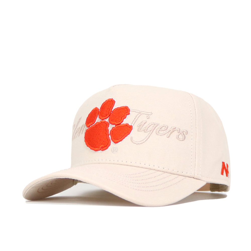 The Clemson Stacked Hat by No Rivals is a beige, officially licensed cap with an orange tiger paw print and "Tigers" embroidered on the front, plus a small orange logo on the left side of the brim. Structured fit.