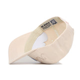 The North Carolina Stacked Hat by No Rivals is a beige cotton baseball cap with a curved bill. "NO RIVALS" and a QR code are printed on the inner headband, and visible stitching lines add detail.