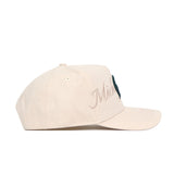 The No Rivals Michigan State Stacked Hat is a beige cotton baseball cap with “Michigan” in cursive on the side panel, a curved brim, visible stitching, and an adjustable snapback closure.