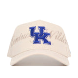 The No Rivals Kentucky Stacked Hat is a beige snapback made from high-quality cotton, with a large blue UK logo and "Kentucky Wildcats" script on the front; officially licensed for fans.