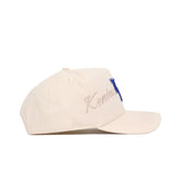 The No Rivals Kentucky Stacked Hat is a beige cotton snapback with “Kentucky” embroidered in cursive on the side and a large blue "K" on the front, shown in a side view.