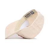 The Nebraska Stacked Hat by No Rivals is a beige snapback, shown inside out to reveal its inner seams, cotton sweatband, and a label with "NO RIVALS" and a QR code under the brim. Made from high-quality cotton for comfort and structure.