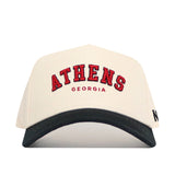 The No Rivals Athens Hometown Hat is a white cotton cap with a black brim, featuring "ATHENS" in large red embroidery above "GEORGIA." This structured snapback offers comfort and style.