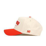 The No Rivals Clemson Hometown Hat is a cream cotton baseball cap with a structured fit, red brim, and embroidered text on front and side. NR initials are stitched on the side, and it features a snapback closure.
