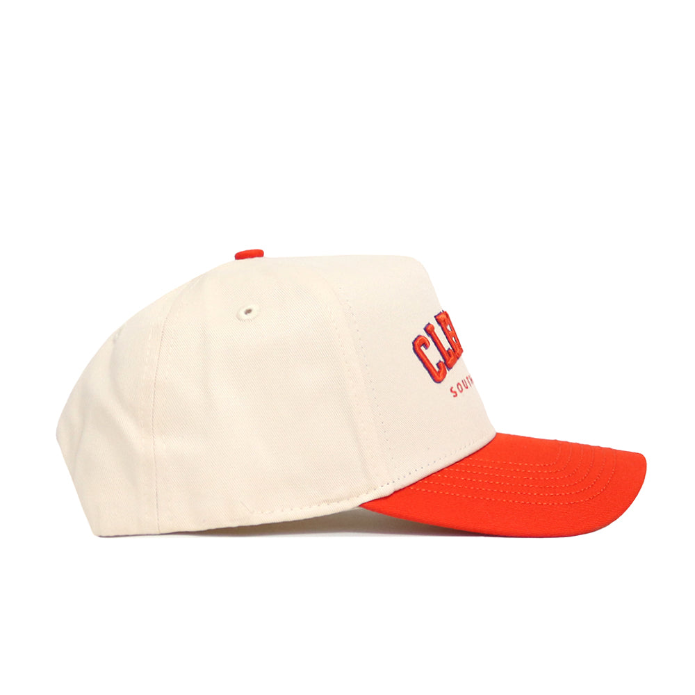 A cream-colored snapback hat from No Rivals, the Clemson Hometown Hat features a bright red brim, red top button, and side embroidery reading “CAL” with smaller text below. Shown in profile against a white background.