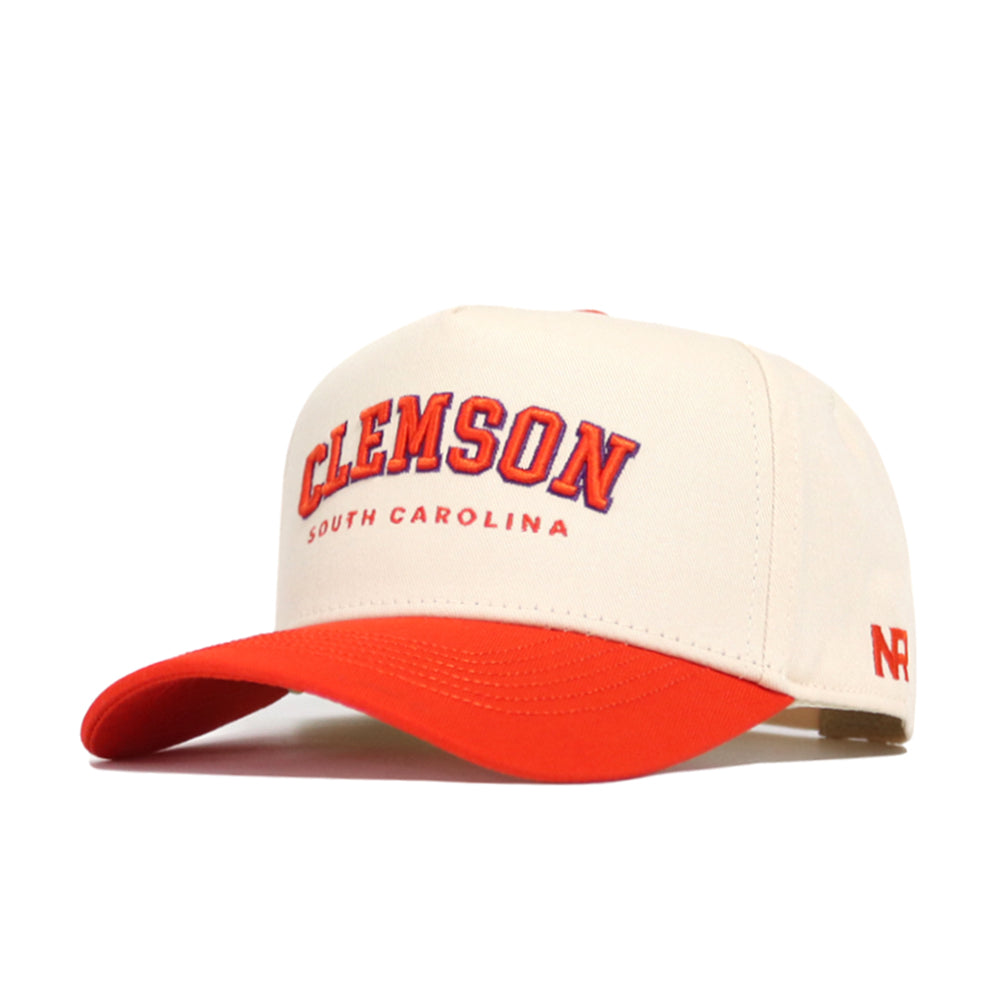 The Clemson Hometown Hat by No Rivals is a cream and orange snapback with "Clemson South Carolina" embroidered in orange and purple, an orange bill, structured cotton fit, and an NR logo on the side.