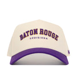 The No Rivals Baton Rouge Hometown Hat is a white cotton baseball cap with a purple brim, featuring BATON ROUGE in purple and gold and LOUISIANA in small purple letters on the front. It has a structured fit and snapback closure for style and comfort.