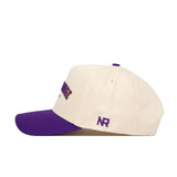 The Baton Rouge Hometown Hat by No Rivals is a cream snapback with a purple brim, made from soft cotton. It features purple embroidery on the side and NR initials near the back, all set against a white background.