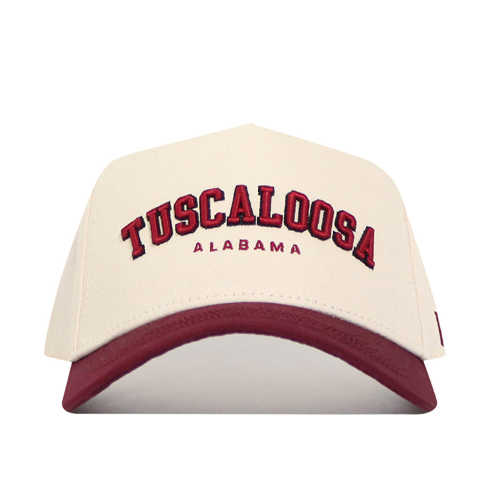 The No Rivals Tuscaloosa Hometown Hat features beige cotton fabric, "Tuscaloosa" in large red and "Alabama" in smaller red embroidery, a maroon curved brim, and a structured fit for comfort.