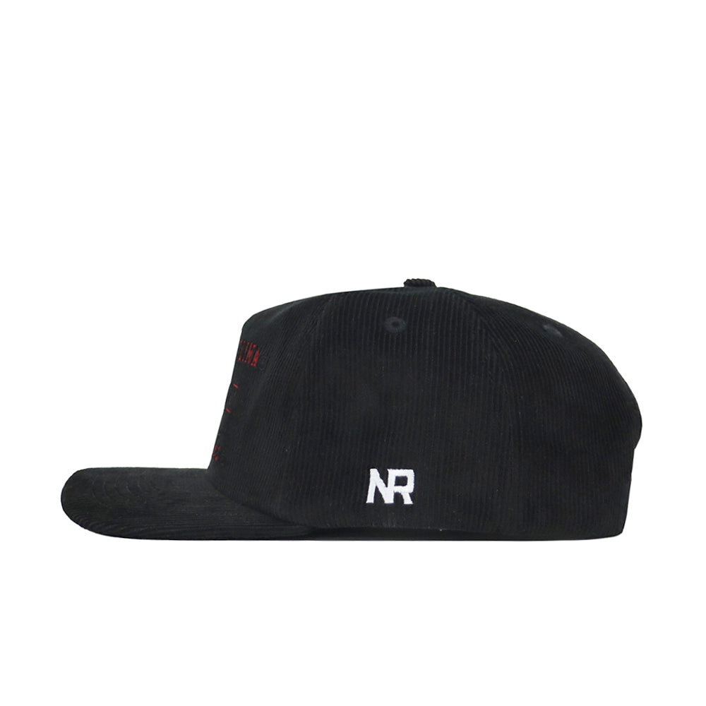 The South Carolina Vintage Cord Hat in black is displayed in profile, showing its unstructured fit and white embroidered NR letters on the side near the back.