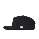 The South Carolina Vintage Cord Hat in black is displayed in profile, showing its unstructured fit and white embroidered NR letters on the side near the back.