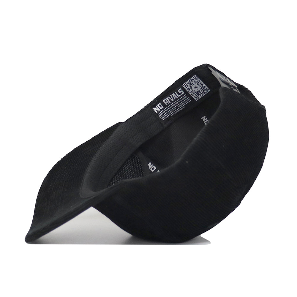 The South Carolina Vintage Cord Hat - Black is displayed on its side, showcasing its unstructured fit with a visible NO RIVALS tag and a QR code sewn into the inner seam.