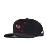 The South Carolina Vintage Cord Hat - Black is an unstructured snapback with "South Carolina Gamecocks" and a gamecock logo embroidered in red and white on the front, plus a white NR logo on the side.