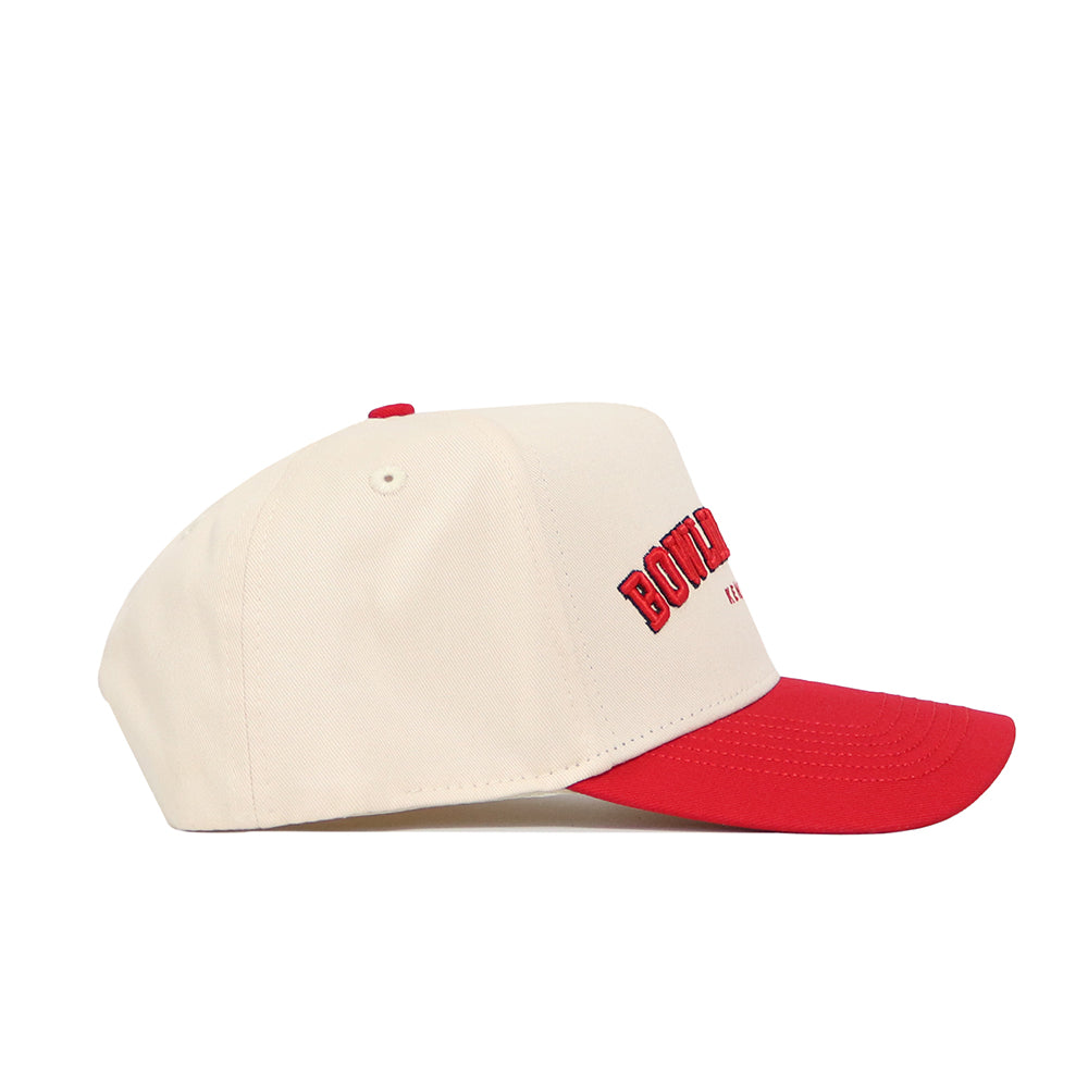 The No Rivals Bowling Green Hometown Hat is cream-colored with a red brim, red top button, and "BON" red embroidery on the side. Made from premium cotton, it features a structured fit and snapback closure for comfort.