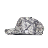 A side view of the No Rivals Montana State Outland Hat, a camouflage-patterned snapback in green, brown, and gray cotton with a flat brim and no visible logos or designs on this side.