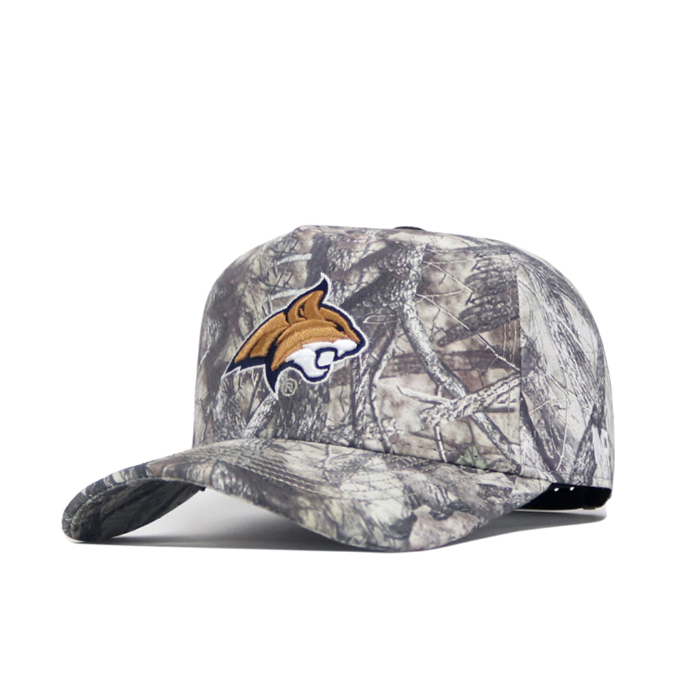 The No Rivals Montana State Outland Hat is a camouflage cotton cap with a gold and white wildcat logo on the front, shown at an angle on a white background. This adjustable hat combines comfort and style for any occasion.