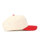 Cream-colored No Rivals NC State Slobbering Wolf Hat snapback with a red brim and red top button, featuring embroidered wolf mascot graphics on the side.