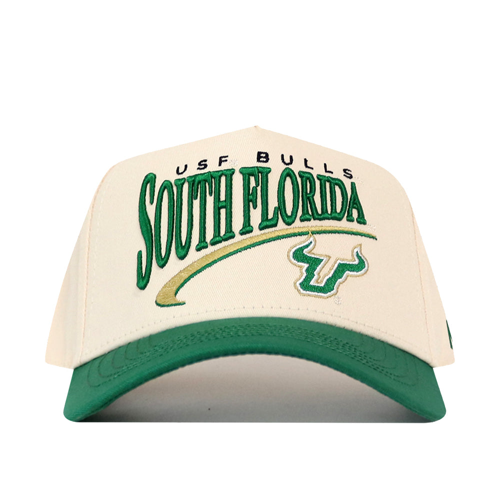 Cream-colored No Rivals USF Stride Hat with a green brim, featuring embroidered SOUTH FLORIDA text, the USF BULLS logo, and a bull horn icon in green and gold.