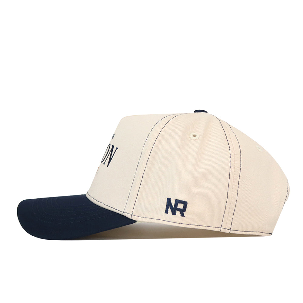 Cream-colored Akron Zips Vintage Hat with a dark blue brim and an embroidered NR logo on the side.