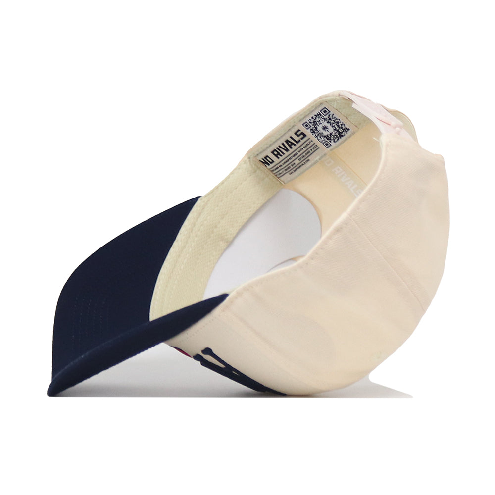 The No Rivals Arizona Wildcats Stride Hat, crafted from high-quality cotton in beige and navy blue, is shown upside down with its structured brim resting on a white surface, revealing the inner label and a QR code on the sweatband.