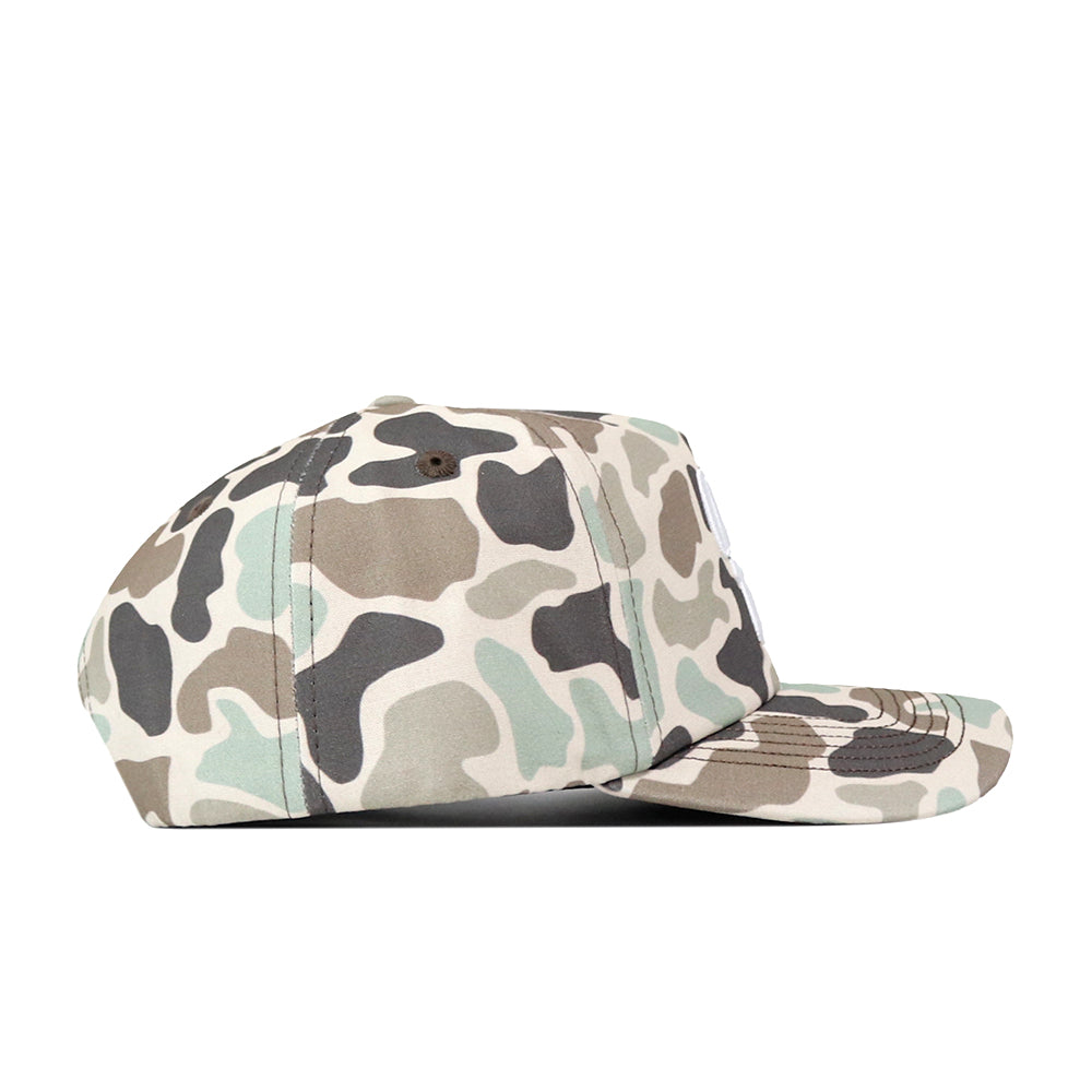 Side view of the No Rivals Ole Miss Rebels Huntsman Hat, an officially licensed flat-brim baseball cap featuring a green, brown, beige, and black camouflage pattern made from high-quality cotton, displayed on a white background.