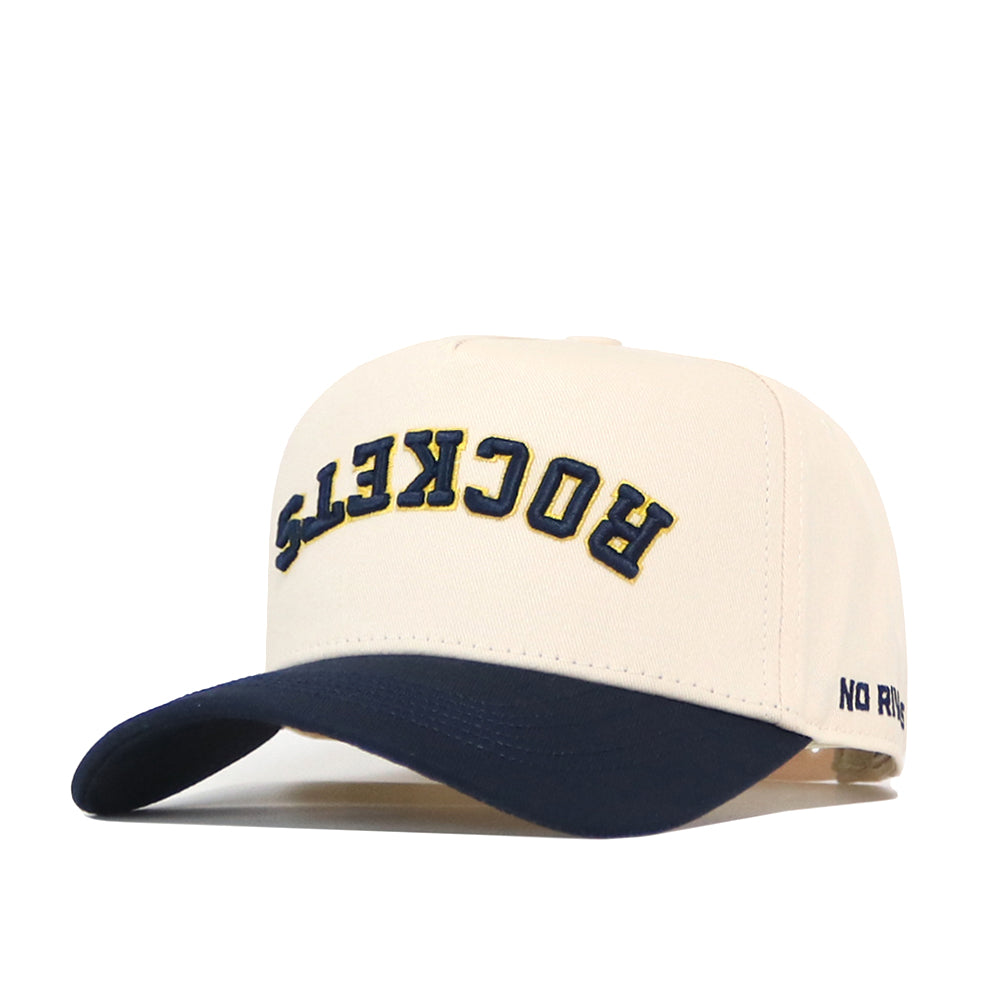Introducing the No Rivals Toledo Rockets | Upside Down Rockets Hat - Classic: this cream-colored snapback baseball cap features a navy blue brim, with “ROCKETS” stitched upside down in bold yellow and navy letters on the front and “NO RUSH” embroidered on the side. It’s a standout choice for any Toledo Rockets hat collector!.