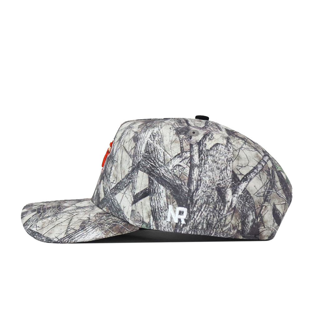 A side view of the No Rivals Bowling Green State Falcons Outland Hat showcases a white embroidered NR logo on the lower side and subtle red embroidery on the front. This camouflage baseball cap features a flat brim, classic woodland pattern, and an adjustable snapback—making it the perfect Gameday Fit.