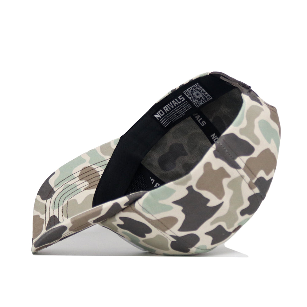 The Oklahoma Huntsman Hat by No Rivals is displayed angled from the bottom, showing its black sweatband and inner "NO RIVALS" label. This 5-panel duck camo cap rests on a white surface.