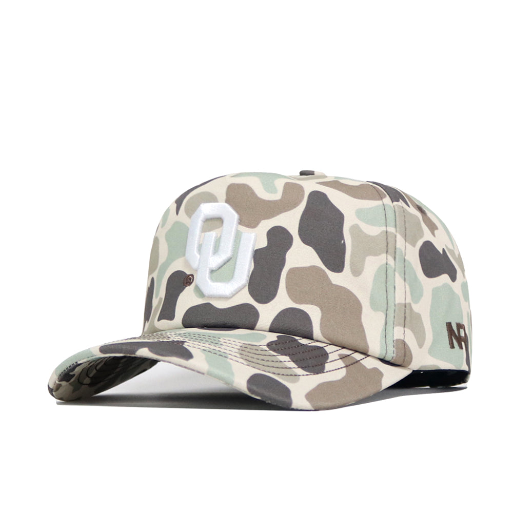 The Oklahoma Huntsman Hat by No Rivals features a white OU logo on duck camo, a small 47 logo on the side, and a 5-panel design blending beige, green, and brown for classic style.